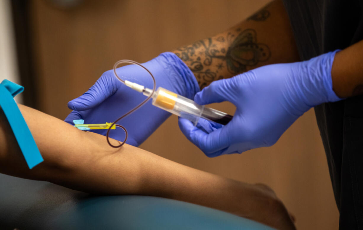 Phlebotomist Latrell Anderson draws blood last week at the AIDS Healthcare Foundation Wellness Center in Los Angeles.