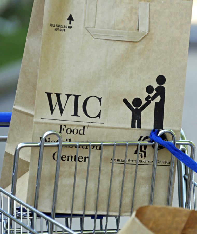 FILE - In this Oct. 3, 2013 file photo, a special supplemental nutrition program for women, infants and children, better known as WIC, bag sits on a shopping cart waiting to be loaded into a recipient's vehicle at a center in Jackson, Miss.  (AP Photo/Rogelio V.