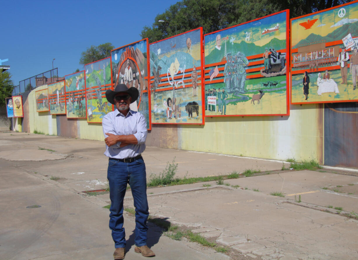 Rock Ulibarri stands in front of "The People's History of El Norte," an 11-panel chronology of Las Vegas mural he designed and was then vividly painted by some 300 high school students.