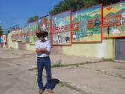 Rock Ulibarri stands in front of "The People's History of El Norte," an 11-panel chronology of Las Vegas mural he designed and was then vividly painted by some 300 high school students.