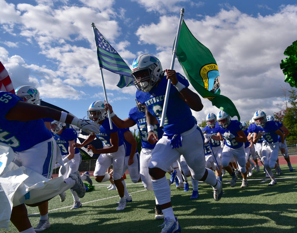 Mountain View junior Jaden Brown, right, carries the Washington state flag pregame Friday, Sept. 1, 2023, at McKenzie Stadium.