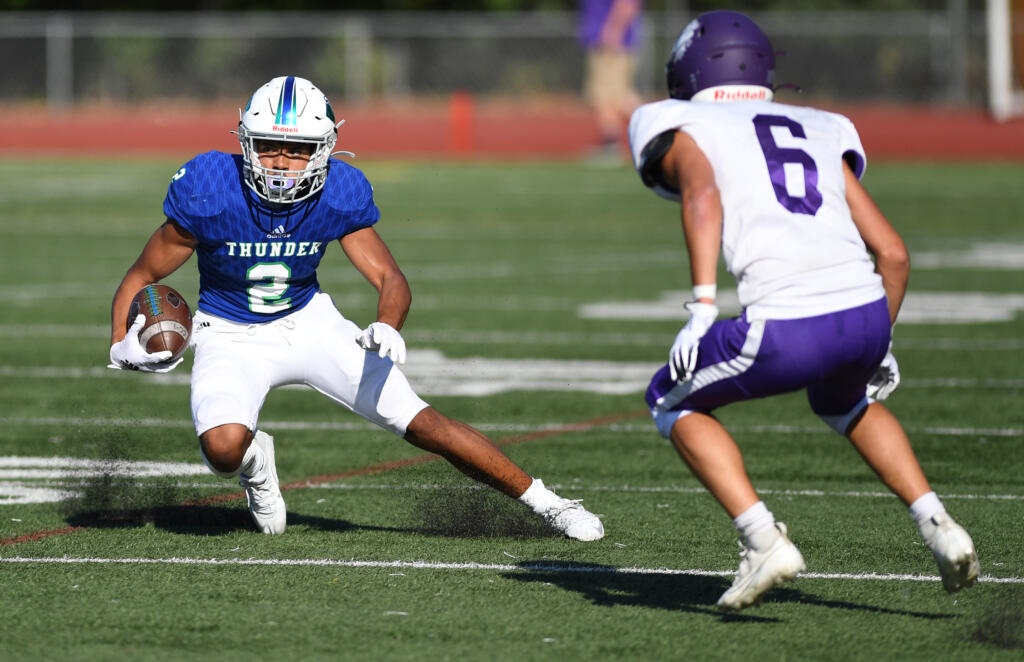 Mountain View senior Akili Kamau, left, cuts to avoid a defender Friday, Sept. 1, 2023, during the Thunder’s 35-21 loss to Nooksack Valley at McKenzie Stadium.