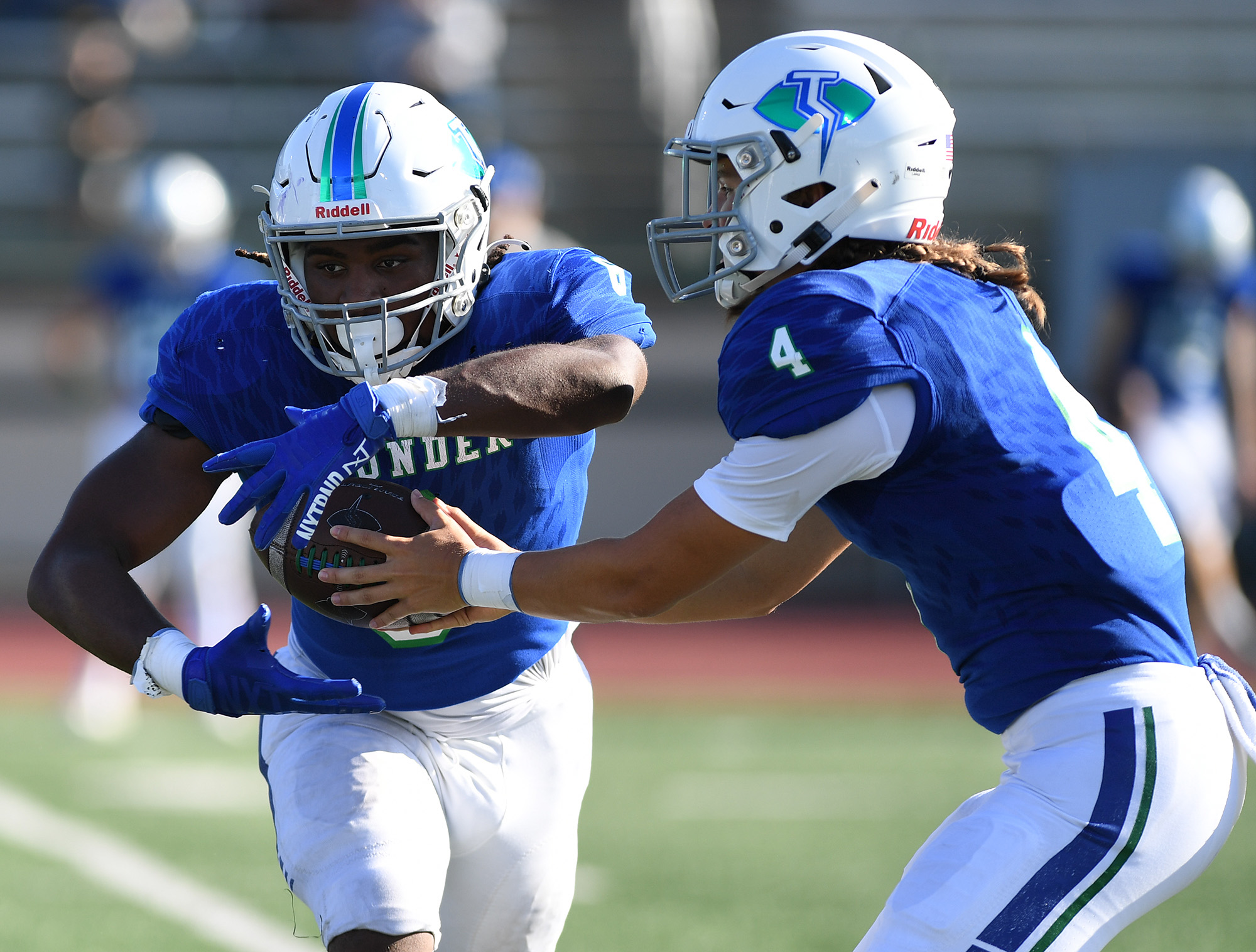 Mountain View senior Cash Cook, right, hands the ball off to junior Jaden Brown on Friday, Sept. 1, 2023, during the Thunder’s 35-21 loss to Nooksack Valley at McKenzie Stadium.