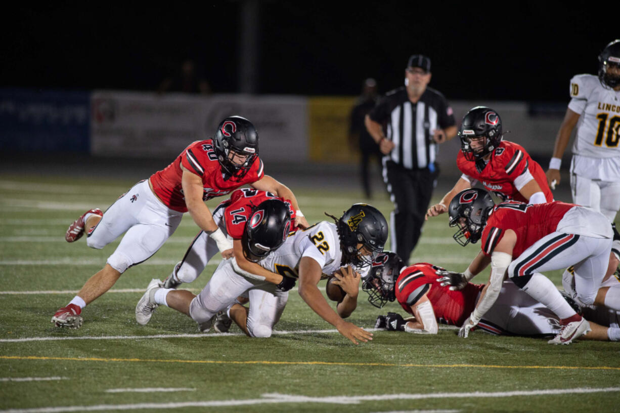 Camas junior Beau Harlan (14) makes a tackle on Lincoln's Jadeon Scranton (22) during Friday's game.