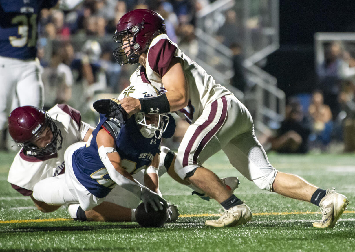 Seton Catholic sophomore Teddy Wieczorek, center, dives through Stevenson senior Jordan Waymire, left, and Stevenson junior Kasen Polzel, right, for a touchdown Friday, Sept. 22, 2023, during the Cougars’ 59-0 win against Stevenson at Seton Catholic High School.