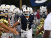 Seton Catholic junior Joe Callerame runs high fives teammates and cheerleaders Friday, Sept. 22, 2023, during the Cougars’ game against Stevenson at Seton Catholic before School.