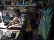 Local artist Patty White, who is visually impaired, uses a special light to help her see as she works on an unspun wool scarf in her Vancouver studio.