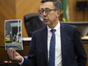 Clark County Prosecutor Tony Golik holds a photo of defendant Guillermo Raya Leon on Monday during the prosecution's closing arguments in Raya Leon's murder trial at the Clark County Courthouse.