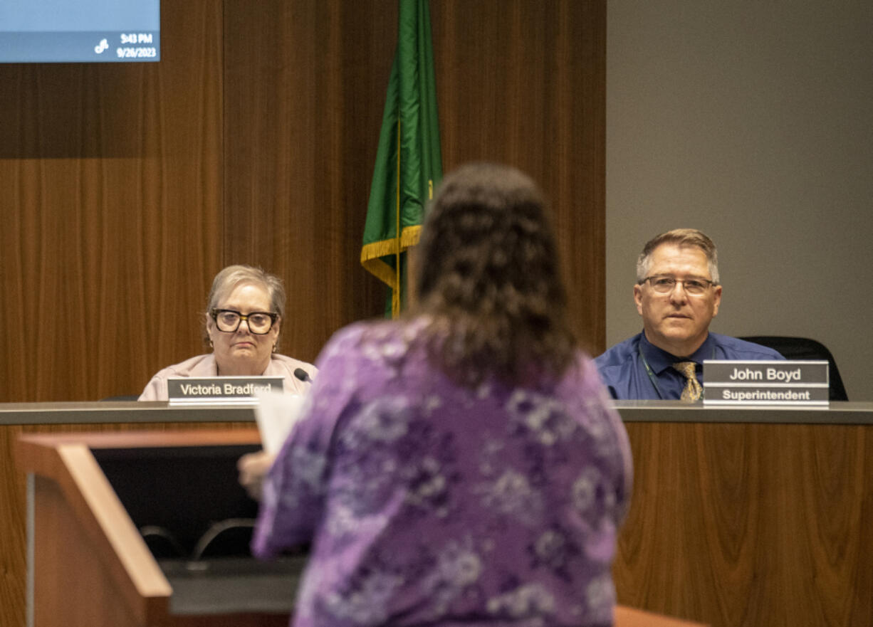 Evergreen school board members Victoria Bradford, left, and Superintendent John Boyd, right, listen to public comment Tuesday evening during a board meeting at Evergreen headquarters. Like other meetings in recent months, Tuesday's session featured testimonies from parents frustrated with unaddressed safety concerns and staffing shortages.