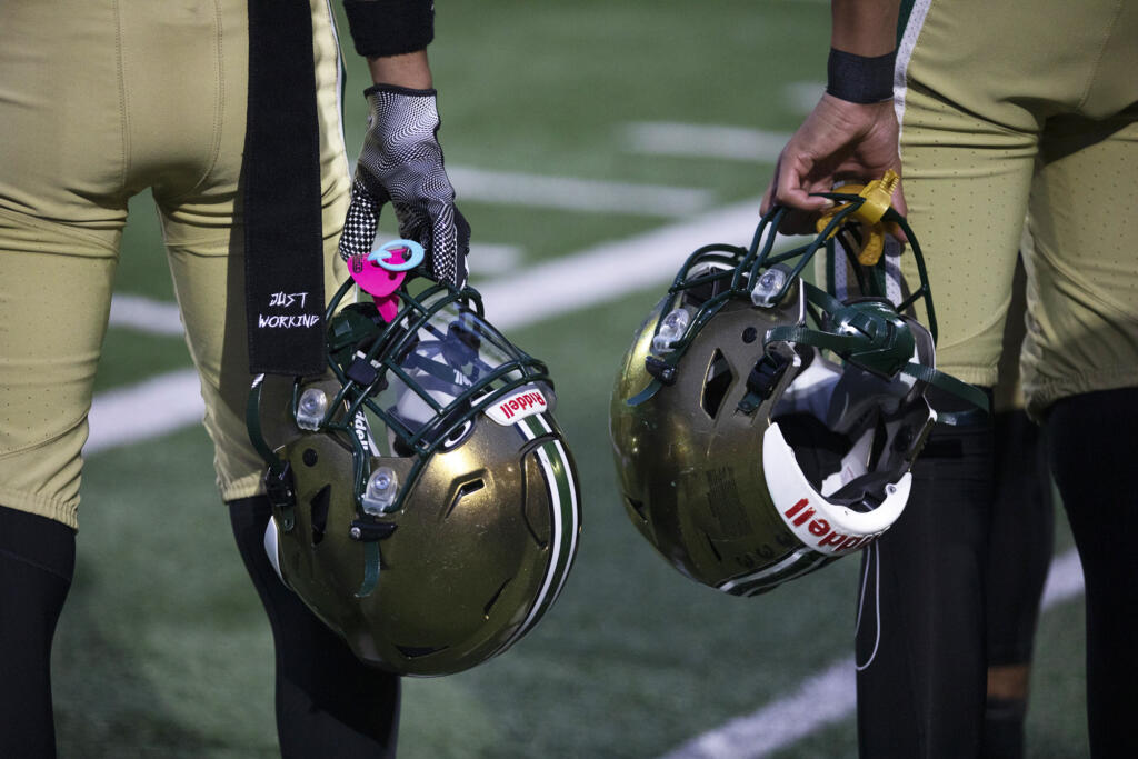 Evergreen players hold their helmets on the sideline before a game against Mountain View at McKenzie Stadium on Friday, Sept. 29, 2023.