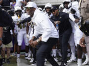 Colorado head coach Deion Sanders runs onto the field with his team for an NCAA college football game against TCU Saturday, Sept. 2, 2023, in Fort Worth, Texas.