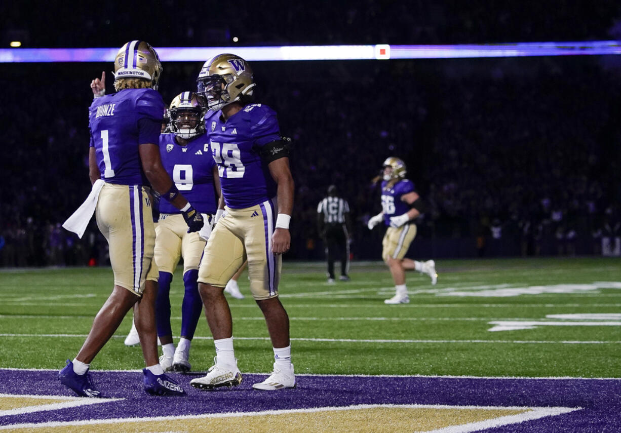 Washington wide receiver Rome Odunze (1) celebrates his touchdown against California with quarterback Michael Penix Jr. (9) and running back Sam Adams II (28) during the first half of an NCAA college football game Saturday, Sept. 23, 2023, in Seattle.