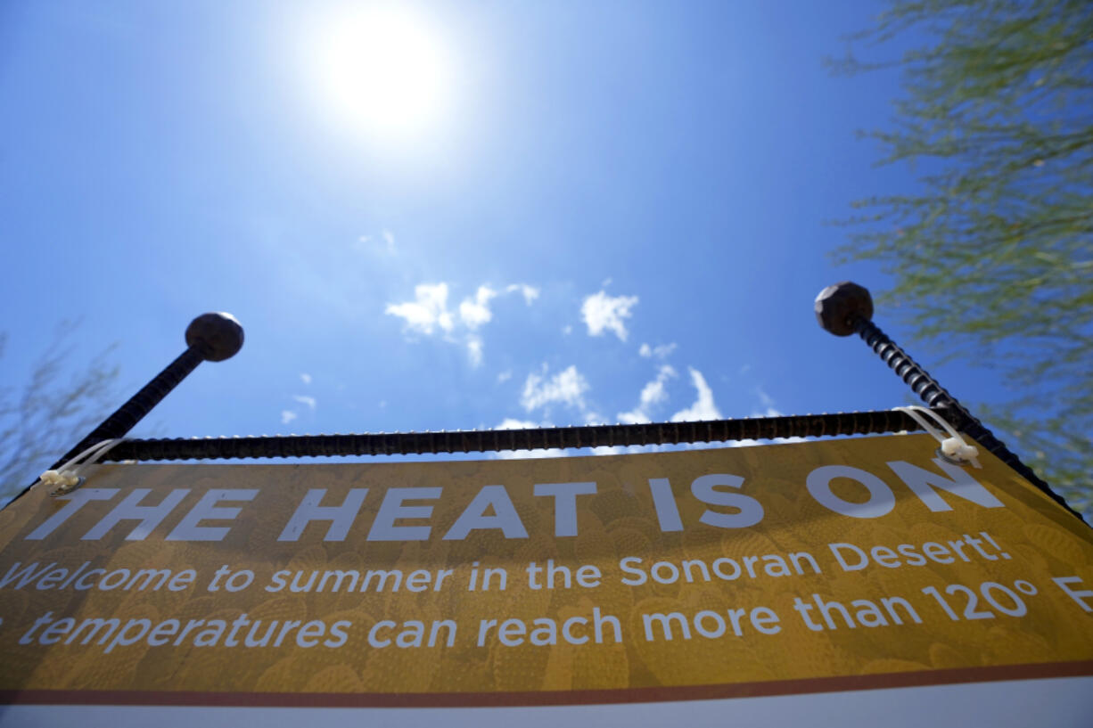 FILE - Patrons are warned about the heat at the Desert Botanical Garden entrance, Wednesday, Aug. 2, 2023, in Phoenix. America's hottest big metro is on track to set an annual record for heat-associated deaths after a sweltering Phoenix summer. (AP Photo/Ross D.