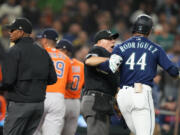 Seattle Mariners' Julio Rodriguez (44) is held back by an umpire after he exchanged words with Houston Astros relief pitcher Hector Neris following a strikeout in a baseball game Wednesday, Sept. 27, 2023, in Seattle. The Astros won 8-3.