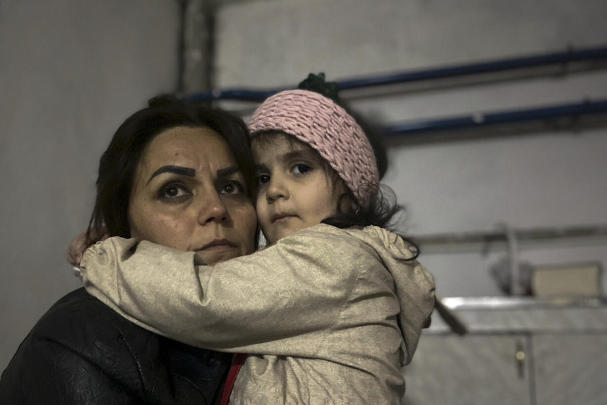 A girl embraces her relative sitting in a shelter during shelling in Stepanakert in the breakaway territory of Nagorno-Karabakh in Azerbaijan. Azerbaijan on Tuesday, Sept. 19, 2023, declared that it started what it called an "anti-terrorist operation" targeting Armenian military positions in the Nagorno-Karabakh region and officials in that region said there was heavy artillery firing around its capital.