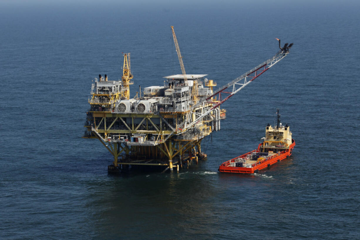 FILE - This April 10, 2011, file photo, shows a rig and supply vessel in the Gulf of Mexico, off the coast of Louisiana.  The Biden administration on Friday proposed up to three oil and gas lease sales in the Gulf of Mexico over the next five years -- and none in Alaska -- as it tries to navigate between energy companies that have pressed for greater oil and gas production and environmental activists who have urged President Joe Biden to shut down new offshore drilling in the fight against climate change.