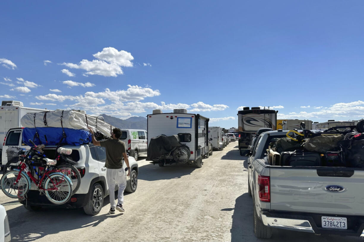 Vehicles line up in a several-hour wait to leave the Burning Man festival in Black Rock Desert, Nev., on Tuesday.