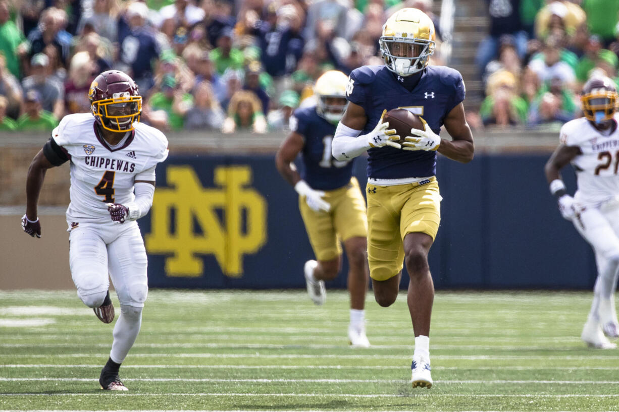 Notre Dame's Tobias Merriweather, right, secures a pass as he runs for a touchdown as Central Michigan's Donte Kent (4) chases him during the first half of an NCAA college football game on Saturday, Sept. 16, 2023, in South Bend, Ind.