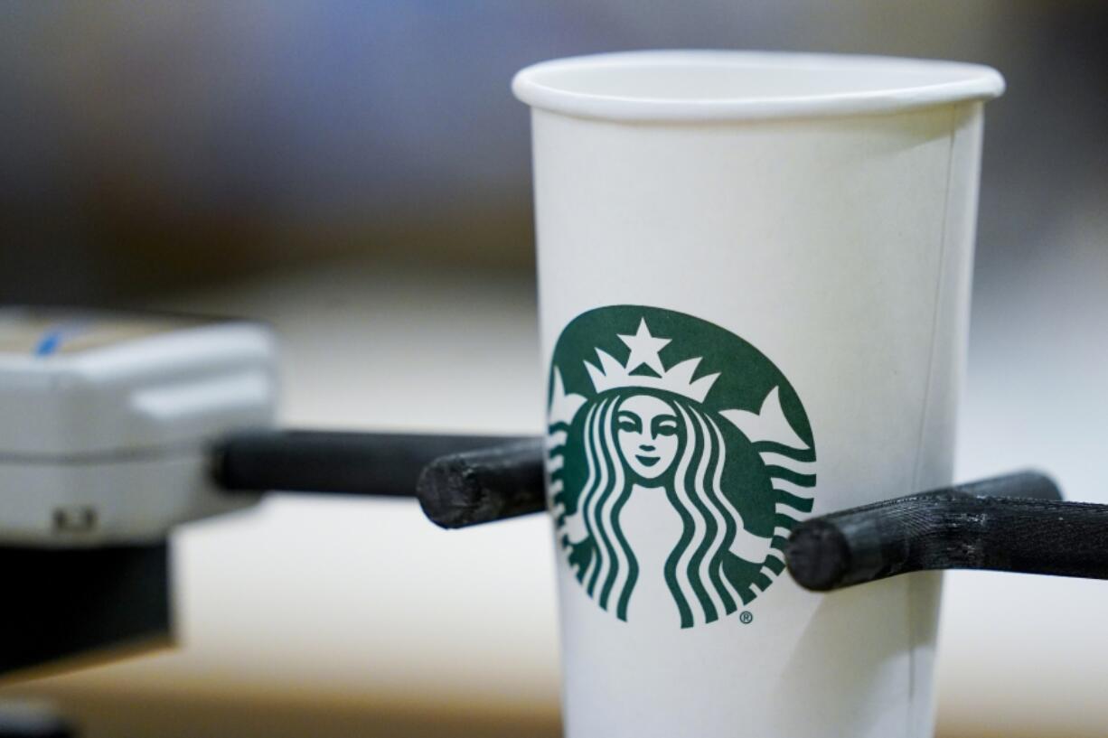 A single-use cup undergoes a rigidity test at the Tryer Center at Starbucks headquarters, Wednesday, June 28, 2023, in Seattle. Paper pulp from recycled cups has shorter fibers than virgin pulp, which means less rigidity, important particularly with hot coffee. Part of the company's goal is to cut waste, water use and carbon emissions in half by 2030.