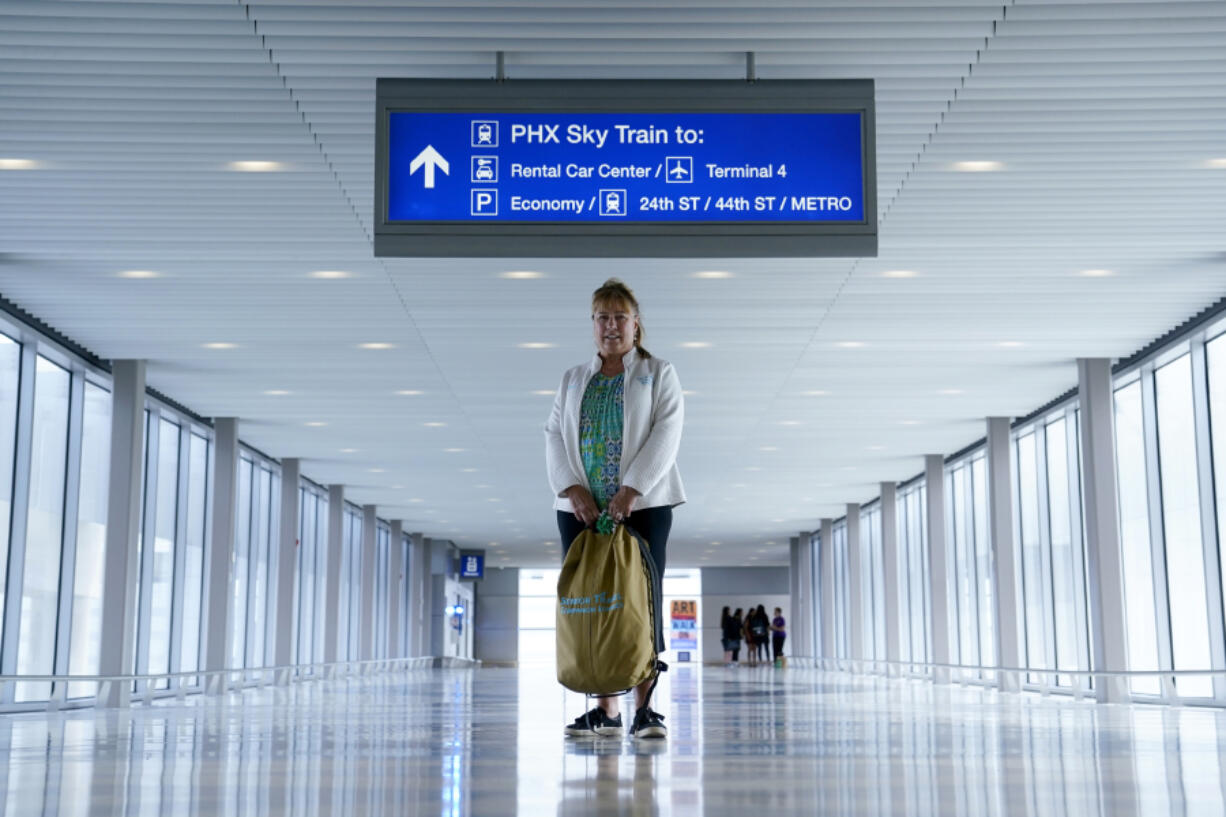 Carol Giuliani, who is a member of the Dementia-Friendly Airports Working group and works as a travel companion for seniors with dementia, stands Aug. 23 in Terminal 3 at Phoenix Sky Harbor International Airport after bringing a client from Minnesota in Phoenix. (Ross D.