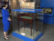 FILE - Luci Baines Johnson looks at the desk on May 16, 2023, on display at the LBJ Presidential Library, that President Lyndon B. Johnson sat at in the President's Room at the U.S. Capitol to sign the Voting Rights Act of 1965, on Aug. 6, 1965. Concern for U.S. democracy amid deep national polarization has prompted the entities supporting 13 presidential libraries dating back to Herbert Hoover to call for a recommitment to the country's bedrock principles, including the rule of law and respecting a diversity of beliefs.