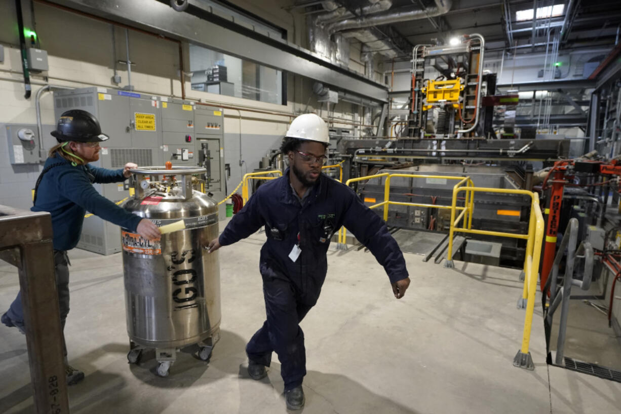 File - Workers transport equipment at Boston Metal on Jan. 25, 2023, in Woburn, Mass. On Friday, the U.S. government issues the August jobs report.