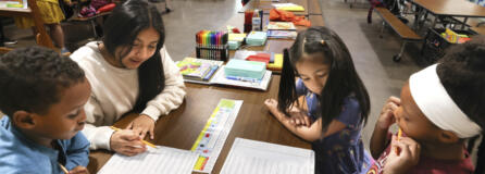 Ayub Mohamed, 7, gets help from volunteer tutor Esmeralda Jimenez, 13, while Olivia Elaydo, 7, and Eden Pollard, 6, work on math problems during a summer tutoring program with School Connect WA at Dearborn Park International Elementary School in Seattle on July 28, 2023.