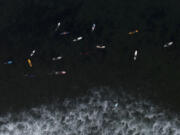 FILE - Surfers float in the water while waiting for a wave in Malibu, Calif., Aug. 31, 2023. Earth is exceeding its "safe operating space for humanity" in six of nine key measurements of its health, and two of the remaining three, one being ocean acidity, are headed in the wrong direction, a new study said. (AP Photo/Jae C.