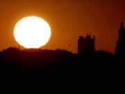 FILE - The sun sets beyond the downtown skyline of Kansas City, Mo., as the autumnal equinox marks the first day of fall Sunday, Sept. 22, 2013. During the equinox, the Earth's axis and its orbit line up so that both hemispheres get an equal amount of sunlight.