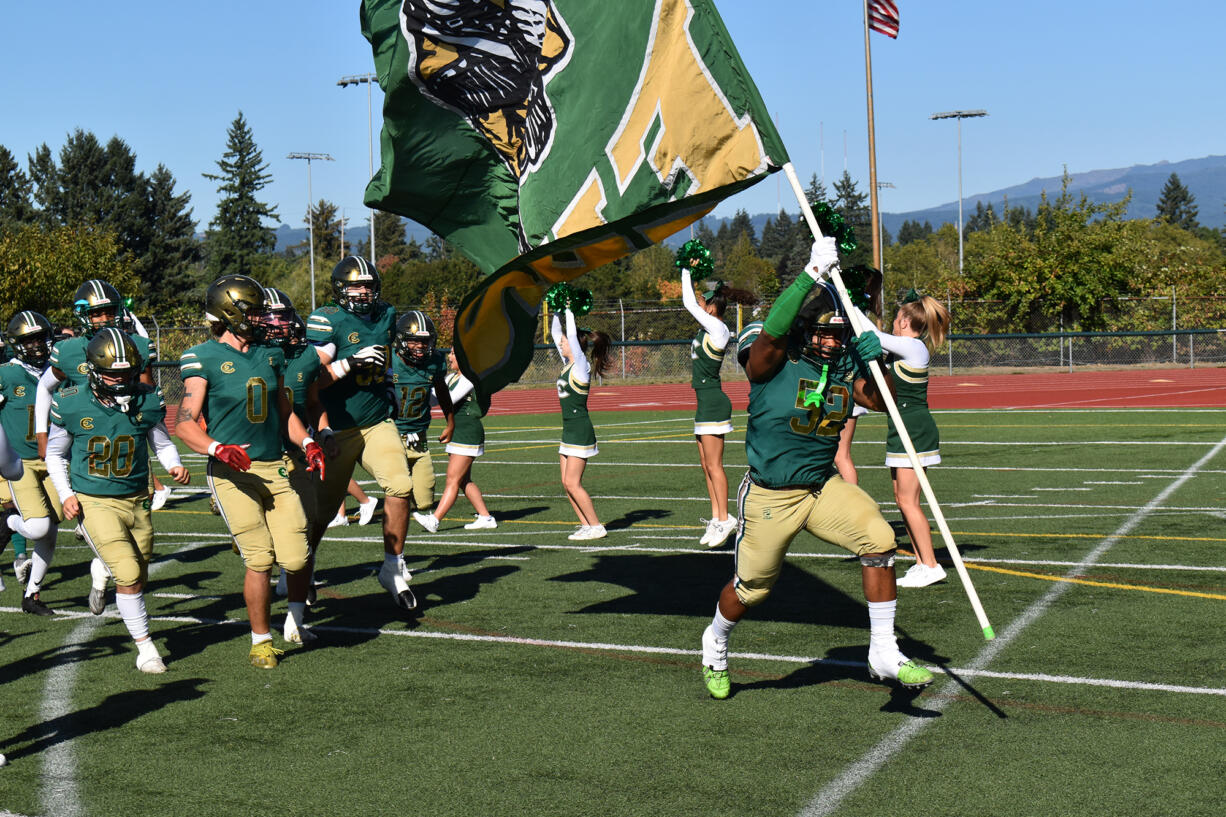 Junior Makhi Miller carries the Evergreen banner onto the field ahead of his teammates before a game against Hockinson at McKenzie Stadium on Friday, Sept. 8, 2023.