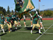 Junior Makhi Miller carries the Evergreen banner onto the field ahead of his teammates before a game against Hockinson at McKenzie Stadium on Friday, Sept. 8, 2023.