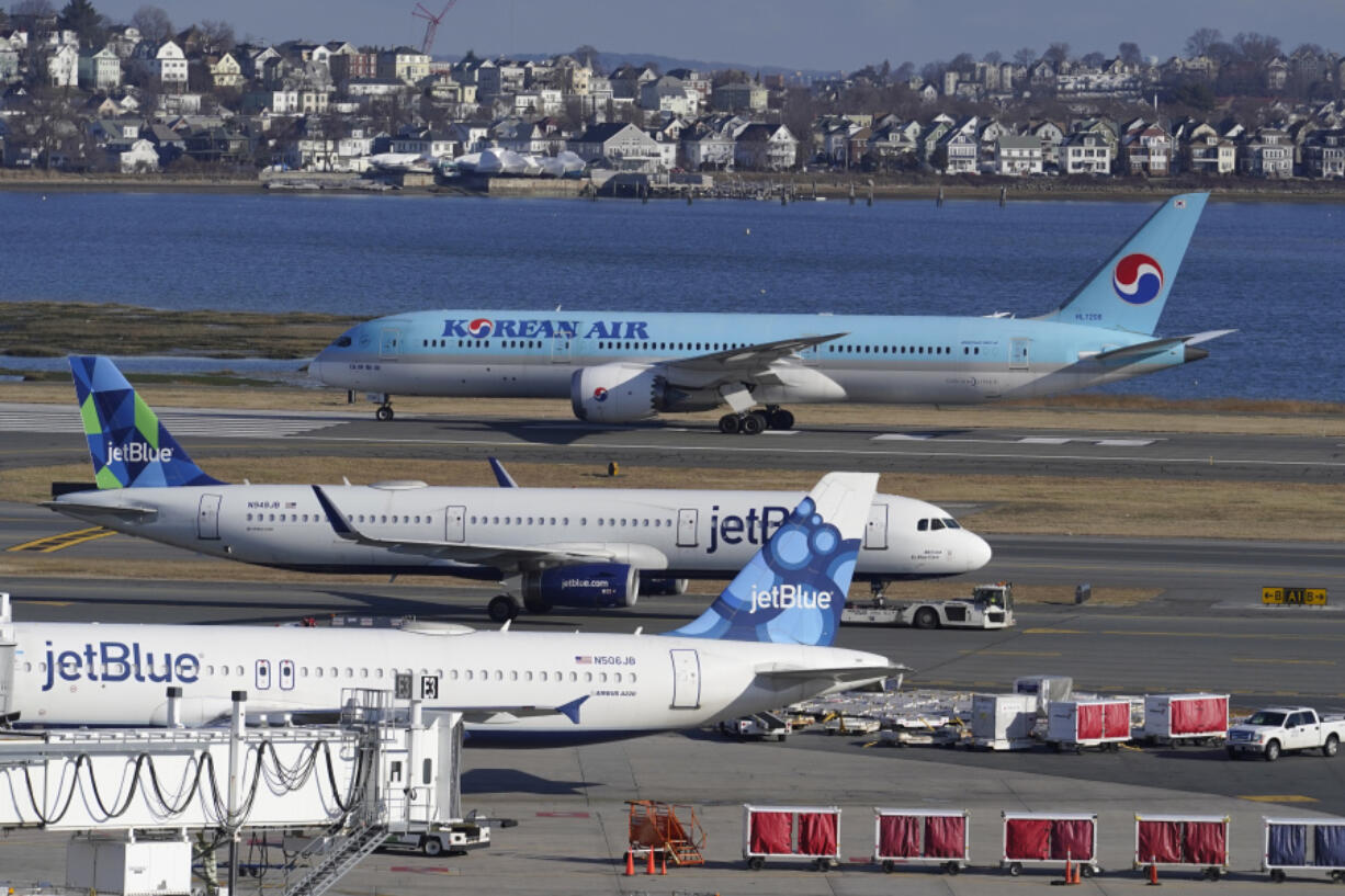 FILE - Passenger jets are seen on the tarmac at Logan International Airport, Jan. 11, 2023, in Boston. The Federal Aviation Administration is considering requiring that all planes be equipped with technology designed to prevent close calls around airports, Friday, Sept. 8.