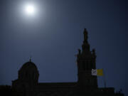 A Vatican Flag waves near the Notre Dame de la Garde Basilica in Marseille, southern France, the day Pope Francis arrives for a two-day visit, Friday, Sept. 22, 2023, when he will join Catholic bishops from the Mediterranean region on discussions that will largely focus on migration.