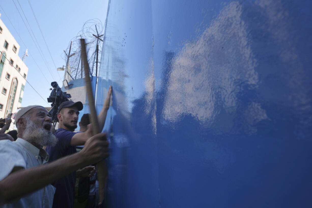 Palestinian demonstrators pound on gates of the United Nations Relief and Works Agency (UNRWA), demanding that the agency fulfil promises to compensate them for losses to their homes during the 2014 war, in Gaza City, Thursday, Sept. 7, 2023. The protest revealed public desperation amid ongoing efforts to alleviate Gaza's housing crisis, including an Egyptian-funded project that aims to complete 1,400 apartments by the end of this year.