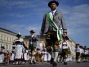 People in traditional Bavarian costumes march during a traditional costume and riflemen's parade at the second day of the 188th 'Oktoberfest' beer festival in Munich, Germany, on Sunday.