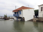 A damaged house stands over the water after the country's record rainfall in Horto village, Pilion region, central Greece, Wednesday, Sept. 6, 2023. Rescue teams in Turkey, Greece and Bulgaria have recovered more bodies following floods after fierce rainstorms.