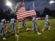 Members of the Hockinson football team take the field prior to their game against R.A. Long at Hockinson High School on Thursday, Sept. 21, 2023.