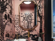 San Francisco-based designer Emilie Munroe, owner of Studio Munroe, created a tiny powder room of a family's Victorian home with an exuberant pink and black animal print wallpaper.