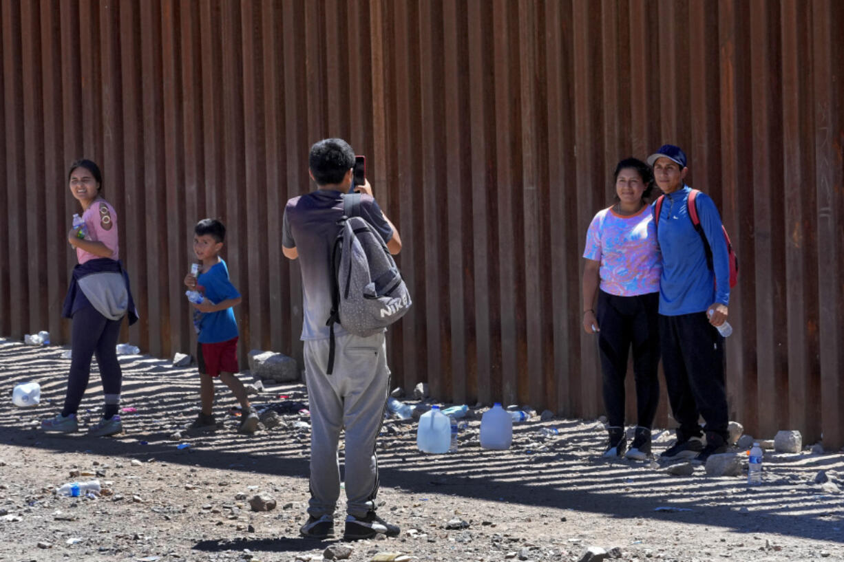 A couple claiming to be from Ecuador pose for a photograph after crossing the border fence in the Tucson Sector of the U.S.-Mexico border, Tuesday, Aug. 29, 2023, in Organ Pipe Cactus National Monument near Lukeville, Ariz. The Border Patrol's Tucson Sector in July suddenly became the busiest along the U.S-Mexico border for the first time since 2008. The area has seen migrants from faraway countries like Pakistan and China, as well as Mauritania, where social media is drawing young people to a new route that goes through Nicaragua. There are also large numbers of people from Ecuador.