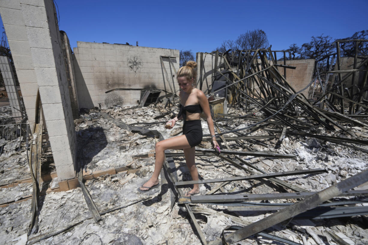 FILE - Sydney Carney walks through her home, which was destroyed by a wildfire, Aug. 11, 2023, in Lahaina, Hawaii. Americans nationwide face hefty increases in their homeowner's insurance premiums in the coming years, a report by the First Street Foundation said on Wednesday, Sept. 20, as climate change intensifies floods, wildfires and storms in ways insurance companies are simply unable to keep up with.