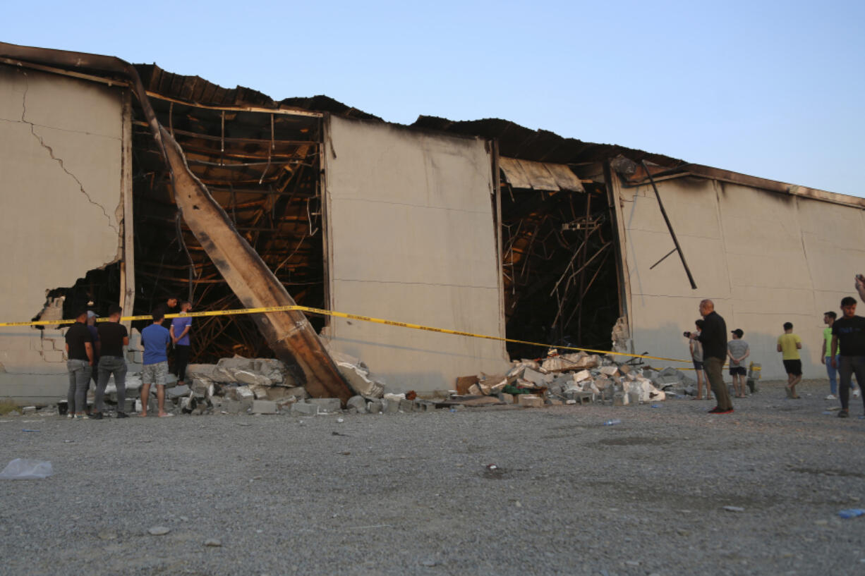 People gather at the site of a fatal fire at a wedding celebration, in the district of Hamdaniya, Nineveh province,  Iraq, Wednesday, Sept. 27, 2023.