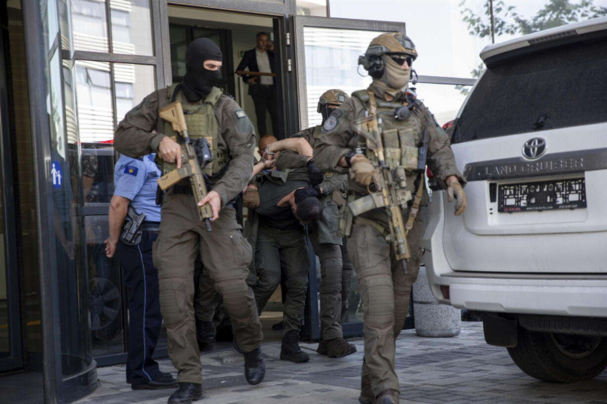 Kosovo police members of Special Intervention Unit escort one of the arrested Serb gunmen out of the court after the Kosovo shootout in capital Pristina, on Tuesday, Sept. 26, 2023. Sunday's clash was one of the worst since Kosovo declared independence from Serbia in 2008. It came as the European Union and the U.S. are trying to mediate and finalize years long talks on normalizing ties between the two Balkan states.