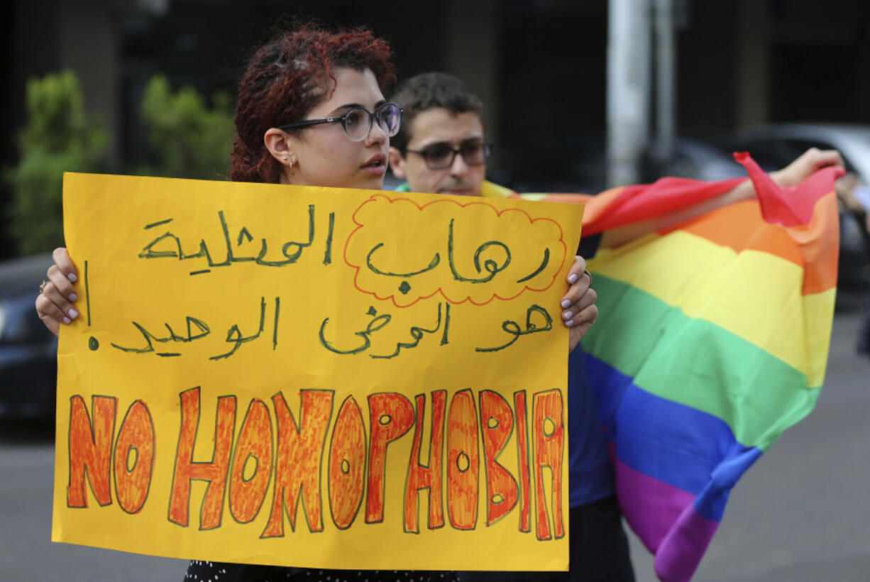 FILE - Supporters of the LGBT (Lesbian, Gay, Bisexual, and Transgender) community attend a sit-in to protest the ongoing criminalization of homosexuality and arbitrary arrests in front of Hobeich police station, where protesters say four men are being held for homosexuality, in Beirut, Lebanon, Sunday, May 15, 2016.