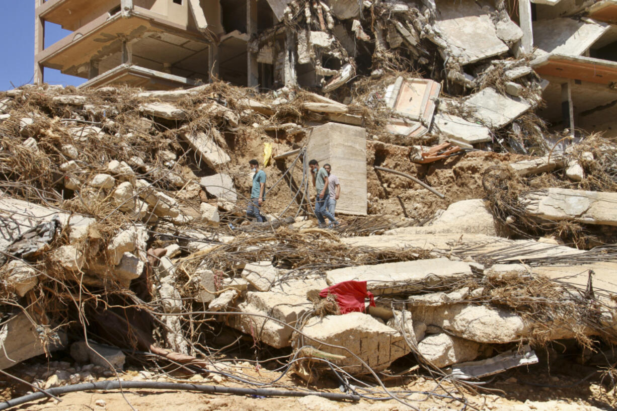 People look for survivors in Derna, Libya, Wednesday, Sept.13, 2023. Search teams are combing streets, wrecked buildings, and even the sea to look for bodies in Derna, where the collapse of two dams unleashed a massive flash flood that killed thousands of people.