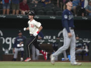 Texas Rangers' Evan Carter heads for home with a three-run home run off Seattle Mariners starting pitcher Bryce Miller, right, during the second inning of a baseball game in Arlington, Texas, Friday, Sept. 22, 2023.