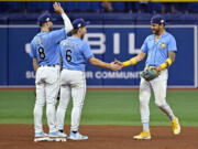 Tampa Bay Rays Brandon Lowe (8), Taylor Walls (6) and Jose Siri celebrate their team's over the Seattle Mariners during a baseball game, Sunday, Sept. 10, 2023, in St. Petersburg, Fla.