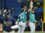 Seattle Mariners third baseman Eugenio Suarez and first baseman Ty France (23) celebrate after the team defeated the Tampa Bay Rays during a baseball game Thursday, Sept. 7, 2023, in St. Petersburg, Fla.