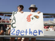 12-year-olds Izzy Aberill, left, and Josie Boyd hold a sign about Washington State and Oregon State being the only two schools left in the Pac-12 after the 2023-2024 academic year after the other schools in the conference announced plans to leave, during the second half of an NCAA college football game between Washington State and Northern Colorado, Saturday, Sept. 16, 2023, in Pullman, Wash. Washington State won 64-21.