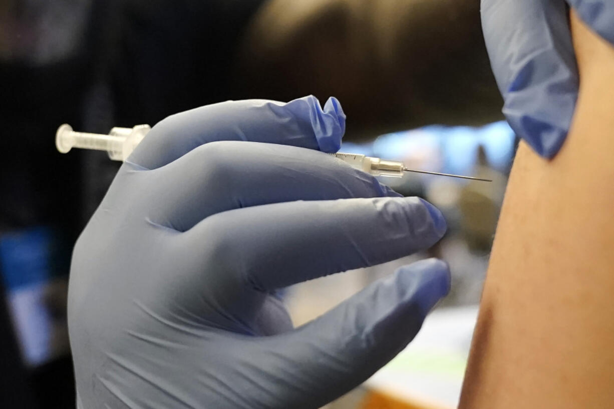 FILE - A person receives a Pfizer COVID-19 vaccine booster shot, Dec. 20, 2021, in Federal Way, Wash. On Sept. 1, 2023, The Associated Press reported on stories circulating online incorrectly claiming that the U.S. Centers for Disease Control and Prevention said that a new COVID-19 variant is more contagious among vaccinated people than those who are unvaccinated. (AP Photo/Ted S.