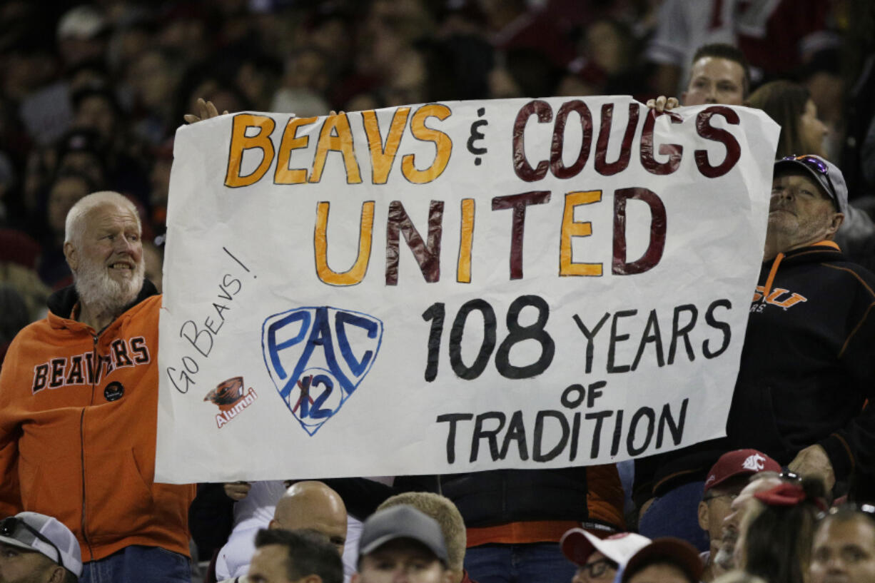 An Oregon State fans hold a "Pac-2" sign, representing the two schools that will remain in the Pac-12 after the 2023-2024 academic year after the other schools in the conference announced plans to leave, during the second half of an NCAA college football game between Washington State and Oregon State, Saturday, Sept. 23, 2023, in Pullman, Wash.